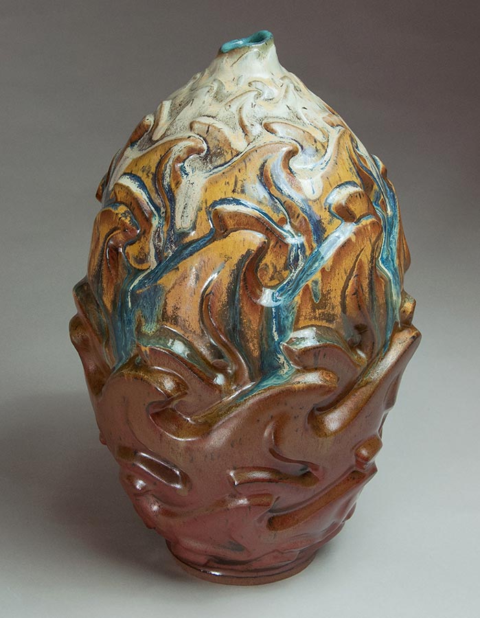 Fire - Rust colored ceramic pot with orange, blue, and white accents
